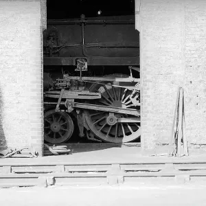Looking across tracks to detail of steam engine in shed Looking across tracks to detail of steam engine in shed
