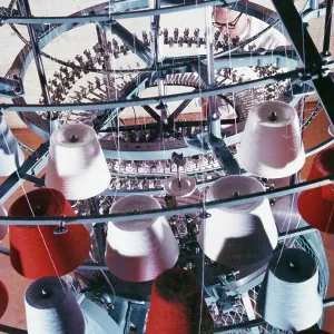 A machine collects coloured yarn onto rolls A machine collects coloured yarn onto rolls