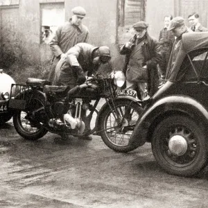 Men standing around an Ariel motorcycle Men standing around an Ariel motorcycle
