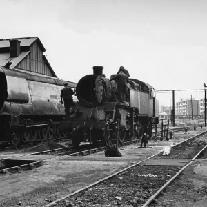 Men working on steam engine at Nine Elms Loco Yard Men working on steam engine at Nine Elms Loco Yard