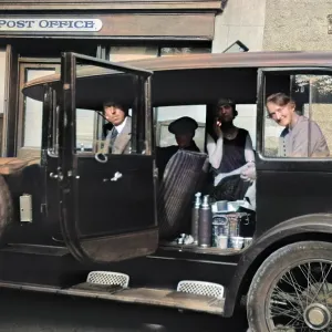 Four people in a car outside a Post Office Four people in a car outside a Post Office