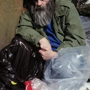 Sleeping Homeless Man Covered with Plastic Bags Sleeping Homeless Man Covered with Plastic Bags
