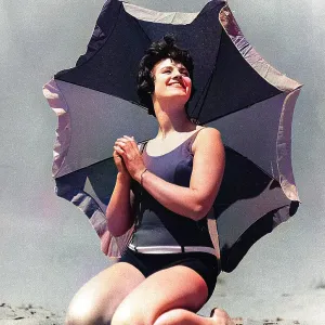 Woman on beach with sunshade Woman on beach with sunshade