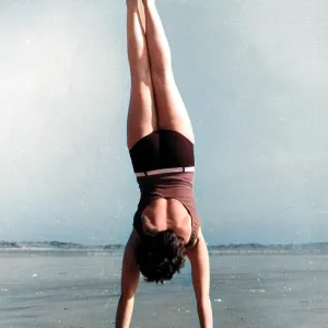 Woman doing handstand on beach Woman doing handstand on beach