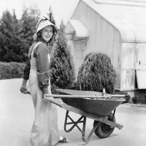 Woman walking with a wheel barrel Woman walking with a wheel barrel