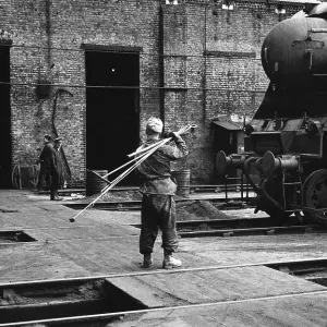 Worker with fire-irons at Nine Elms Old Shed Worker with fire-irons at Nine Elms Old Shed