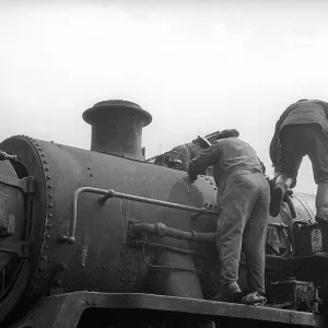 Two workers on steam engine at Nine Elms Loco Yard Two workers on steam engine at Nine Elms Loco Yard