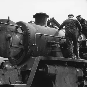 Two workers on steam engine at Nine Elms Loco Yard Two workers on steam engine at Nine Elms Loco Yard