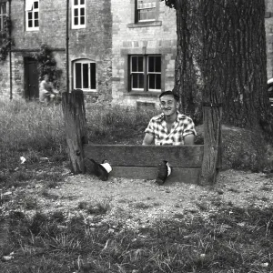Young man fools about in The Stocks Young man fools about in The Stocks