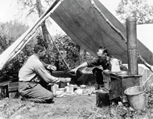 Victuals: 1920s two men eating under a frame tent canvas