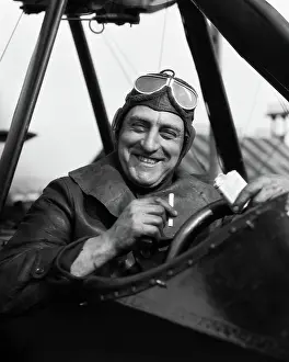 Inhaling: 1920s SMILING MAN PILOT IN COCKPIT OF AIRPLANE