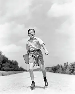 Pre Teen: 1930s 1930s Smiling Boy Roller Skating to School looking