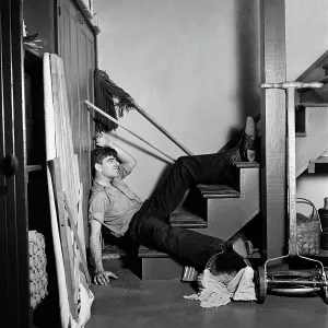 Handyman: 1930s 1940s man lying at bottom basement stairs