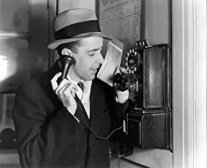 Salesperson: 1930s BUSINESSMAN IN HAT AND SUIT TALKING ON