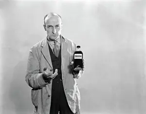 Dour: 1930s Dour Man In Lab Coat Holding