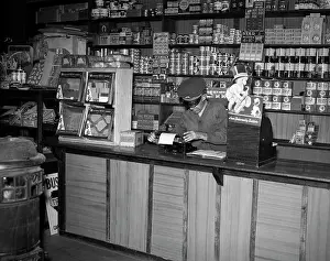 Paneled: 1930s MAN BEHIND COUNTER IN GENERAL STORE USING