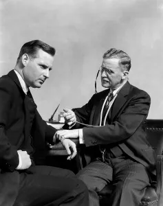 Checkup: 1930s Man Doctor Taking Pulse