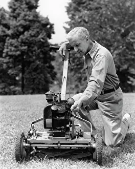 Lawnmower: 1940s ELDERLY MAN IN YARD KNEELING DOWN TO FIX