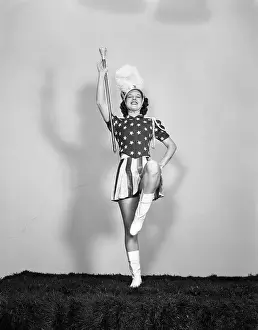 Marcher: 1940s MAJORETTE POSING WITH BATON FACING FORWARD