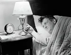 Insomnia: 1940s TIRED MAN IN BED TURNING ON LIGHT NEXT