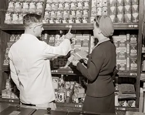 Planner: 1940s Back View Of Grocer Pointing