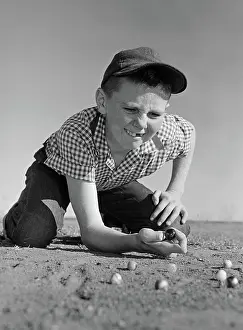 Knuckle: 1950s 1960s BOY PLAYING MARBLES KNEELING IN THE