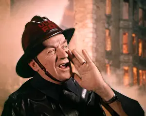 Yell: 1950s 1960s Man Fireman Firefighter Yelling with Burning