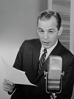 Anchorman: 1950s 1960s SERIOUS MAN SPEAKING INTO MICROPHONE