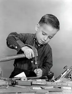 Nailing: 1950s Boy Playing With Hammer