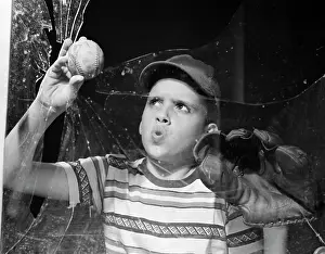 Mitt: 1950s boy in tee-shirt & cap removing baseball
