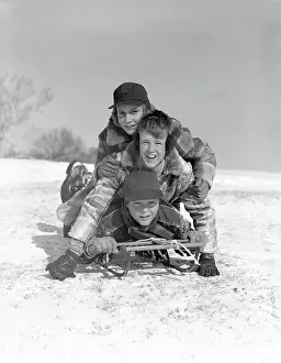 Piling: 1950s THREE BOYS PILED ON TOP OF SLED ON SNOW