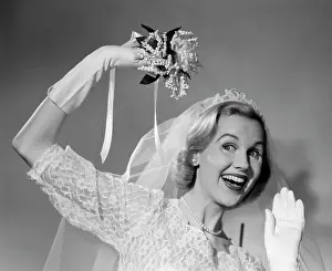 Vows: 1950s BRIDE THROWING BOUQUET AND WAVING GOODBYE