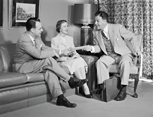 Salesperson: 1950s COUPLE SITTING ON COUCH TALKING TO SMILING