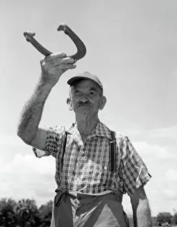 Squint: 1950s ELDERLY MAN SQUINTING ONE EYE GETTING READY