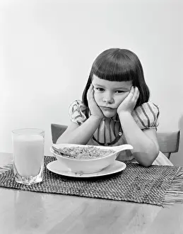 Dislike: 1950s Grumpy Girl Sitting at Table with Bowl of Cereal Gl