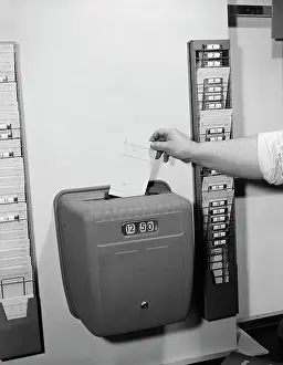 Inserting: 1950s MALE HAND DROPPING CARD INTO TIME CLOCK