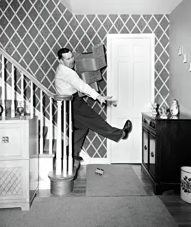 Clumsy: 1950s MAN CARRYING STORAGE BOXES DOWN STAIRS