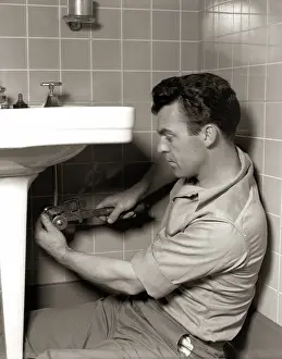 Plumber: 1950s MAN PLUMBER FIXING BATHROOM SINK