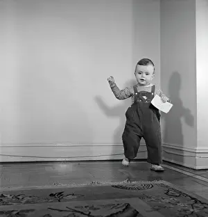 Baseboard: 1950s Toddler Boy Standing Holding