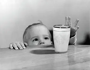 Jhn001: 1950s Toddler Reaching Up To Table