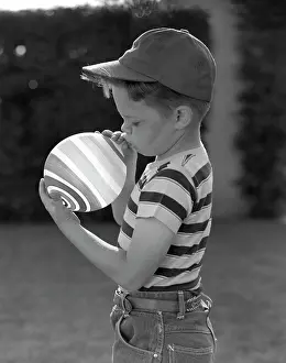 Inflating: 1950s Side View Of Boy In Baseball