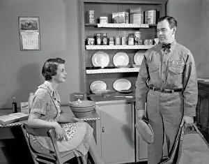 Repairman: 1950s Woman Apron Sitting At Kitchen
