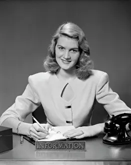 Receptionist: 1950s Woman Sitting At Information