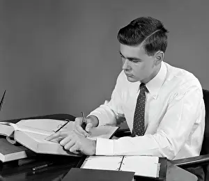 1950s Young Man Sitting At Desk