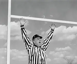 Touchdown: 1960s AMERICAN FOOTBALL REFEREE MAKING TOUCHDOWN