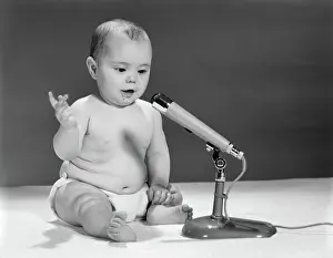 Diapers: 1960s BABY IN DIAPER SPEAKING INTO MICROPHONE