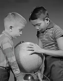 Classmates: 1960s TWO BOYS STUDYING EARTH GLOBE