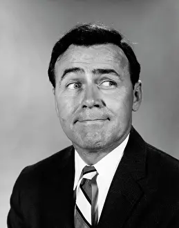Glancing: 1960s BUSINESSMAN MAKING FUNNY FACE LOOKING TO