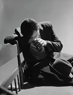 Sufferer: 1960s BUSINESSMAN SITTING ON BENCH HEAD DOWN