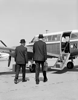 Briefcases: 1960s TWO BUSINESSMEN WALKING TOGETHER TO A SMALL